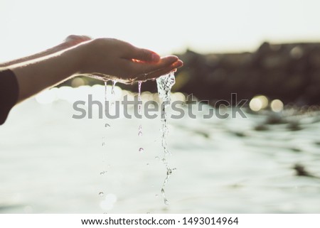 Human hands splashing pure water from sea. Close-up