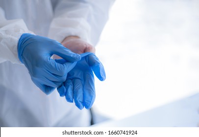 Human Hands Taking Off Blue Disposable Gloves.