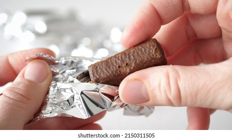 Human Hands Taking And Unwrapping Silver Candy