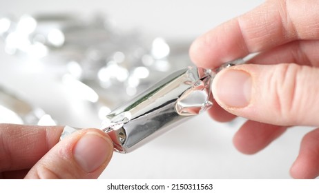 Human Hands Taking And Unwrapping Silver Candy