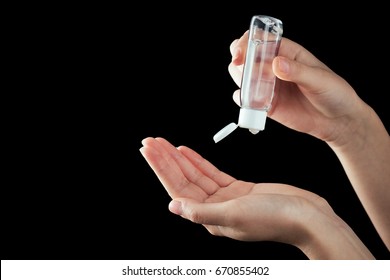 Human hands use a gel, disinfectant, antiseptic in a bubble, jar on a black background