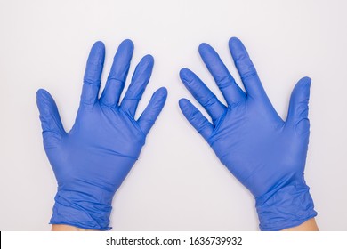 Human hands wearing blue surgical latex nitrile gloves for doctor and nurse protection during patient examination on white background.