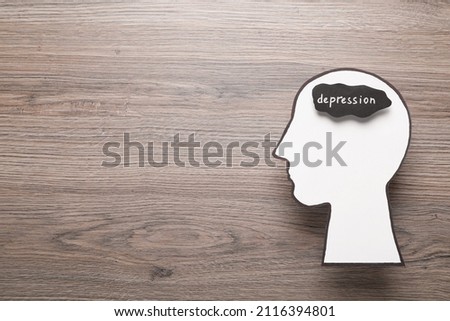 Human head cutout with word Depression on wooden table, top view. Space for text