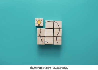 Human head outline on wooden blocks with missing piece light bulb, problem solving, creativity, motivation concept - Shutterstock ID 2233348629