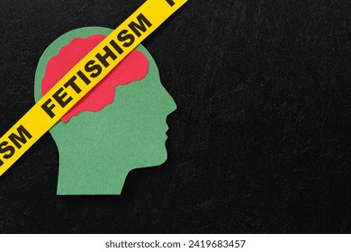 Human head profile with word fetishism in dark black background. Psychological disorder warning concept.	
