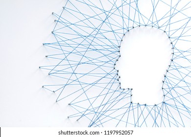 Human head shape made from a large grid of pins connected with string. Communication technology and mental health concept