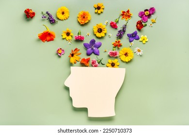 Human head symbol and flowers on blue background. World mental health day concept - Shutterstock ID 2250710373