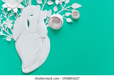 Human Heart Organ Concept With Paper Flowers As A Circulatory Anatomy Made Of Paper As A Medical Health Care Symbol Of An Inner Cardiovascular Body Part On Blue Background.