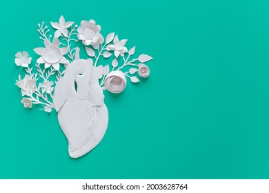 Human Heart Organ Concept With Paper Flowers As A Circulatory Anatomy Made Of Paper As A Medical Health Care Symbol Of An Inner Cardiovascular Body Part On Blue Background.