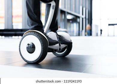 Human Legs And Feet On Hoverboard Over Floor Of Large Contemporary Lounge