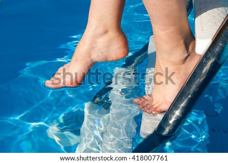 Human legs on the blue water