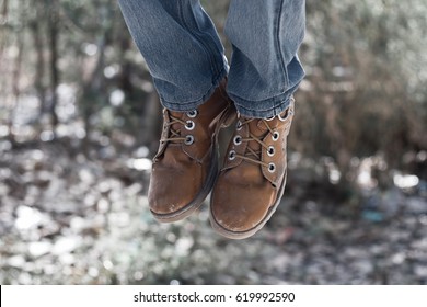 Human legs wearing all weather shoes. sitting and dangling their feet in summer. - Powered by Shutterstock