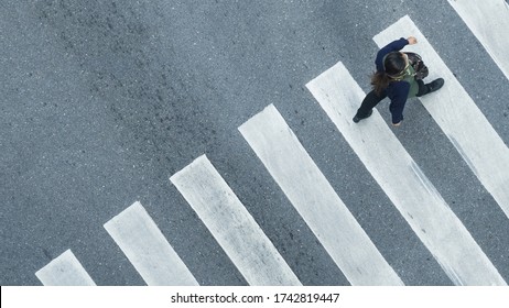 Human Life In Social Distance. Aerial Top View With Blur Man With Smartphone And Group Of People Walking At Pedestrian Crosswalk On Grey Pavement Street Road With Empty Space.