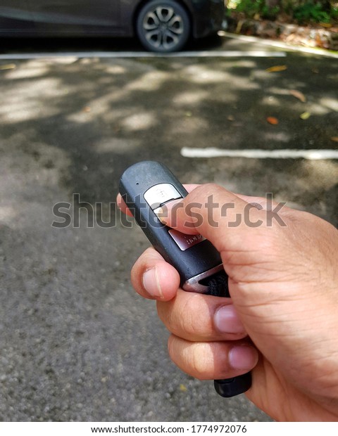 Human man holding key fob
at car park