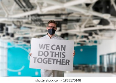 Human In Mask Holding A White Frame Banner With Text 