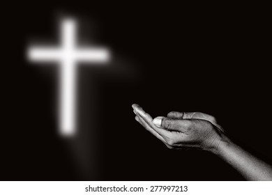 Human open empty hands and the light of God black background.abstract