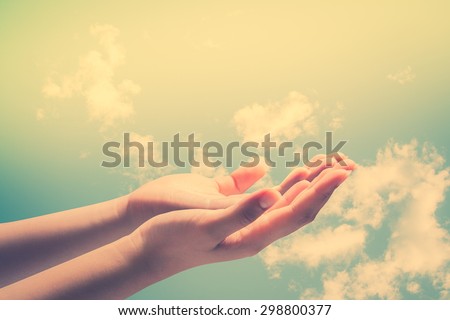 Human open empty hands with palms up, over blurred nature background.