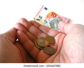 Human Palm With Little Cash. One Day Salary Of European Union's Least Developed Countries. Metal Coins And Paper Banknotes In The Worker Hand. White Background.