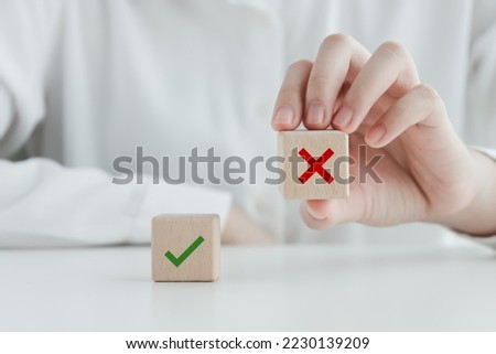 Human pick wrong or red cross icon on wood cube from green check mark for true or false mindset or elections vote, survey and assessment to change leader and transform quiz answer and poll concept. 
