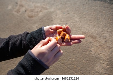 Human Prepares A Dog Sausage Bait With Nails