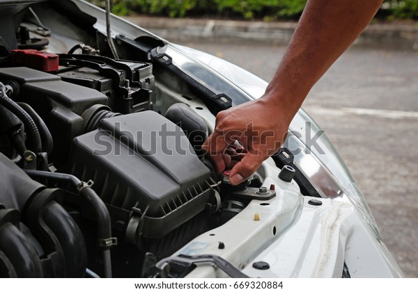 Human preparing and check the radiator of the car\
before departure for\
safety