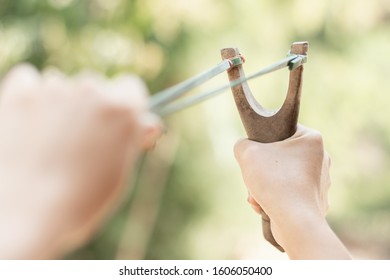 Human Pulling Slingshot And Ready To Fire.