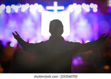 Human raised hands in blurred church service background - Shutterstock ID 2253560703