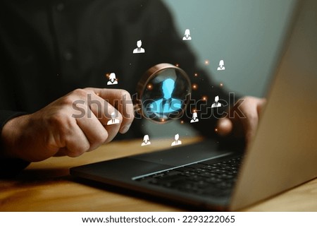 Human Resource Management, HRM, Businessman holding magnifier for searching to human icons for human development and recruitment concept. Customer Relationship Management, customer network technology