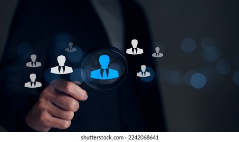 Human Resource Management HRM concept. Businessman holding magnifier for searching to human icons for human concept of development and recruitment, Find the right person for the company organization. - Shutterstock ID 2242068641