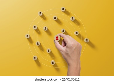 Human resource management and recruitment business concept. Hand holding wood cube with icon people on yellow background - Shutterstock ID 2140170611