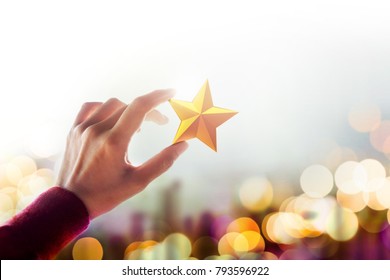 Human Resource Management or Talent Concept, Hand holding and Raise up a Golden Star, Blurred Bokeh Light as background
