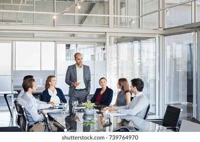 Human resource manager training people about company and future prospects. Group of businesspeople sitting in meeting room and listening to the speaker. Leader man and work group in a conference room.