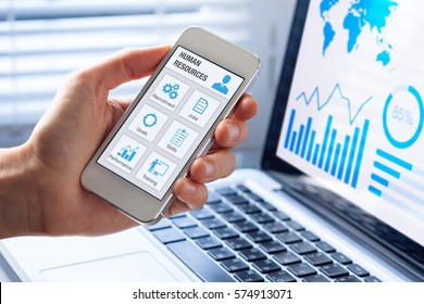 Human Resources (HR) Management App Concept On A Mobile Phone Screen With A Person Hand And Office Interior Background, Icons About Recruitment, Hiring, Jobs, Training