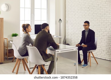 Human resources management and business recruitment. Employers talking to male job candidate. Two HR managers asking young African-American man questions during interview in the company office - Shutterstock ID 1874352358