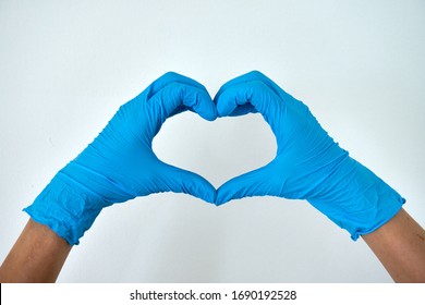 Human rising hands make finger heart shape wearing blue disposable latex glove, rubber glove for professional medical safety and hygiene protection from Coronavirus disease COVID-19 and surgery