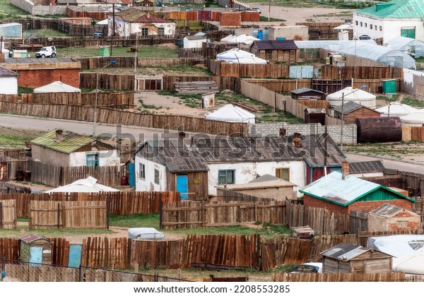 A human settlement\
in the Mongolian steppe with houses, huts, yurts and plots marked\
out by picket fences