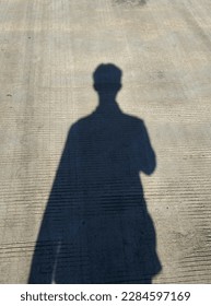 human shadow on cement walkway 