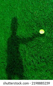 Human Shadow On Green Grass Holding Yellow Tennis Ball Outdoors.  Hand Is  Holding A Tennis Ball. Sports Gear For Tennis