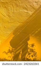 Human shadow on the yellow cement wall, vertical style, outdoor day light, artistic background