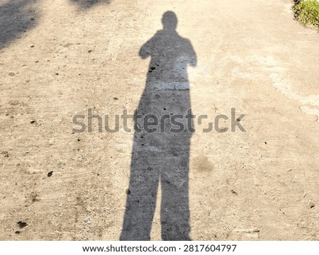 Human Shadow Projected on Concrete Ground Pavement Outdoors on a Sunny Day