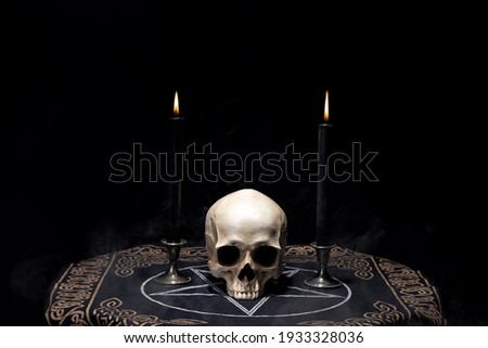  Human skull on pentagram altar cloth with burning candles. Astrology, Occult, black magic ritual.
