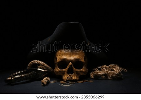 Human skull with sword, toy model of cannon, pirate hat and coins on black background ストックフォト © 