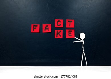 Human Stick Figure Changing Word Fact To Fake. Dark Background. Facts Versus Fake News Concept.