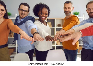 Humanism And Social Responsibility, Business Training And Corporate Coaching Session Concept. Group Of Diverse Multiracial People Different Age Holding Hands Joining Together Front View Shot