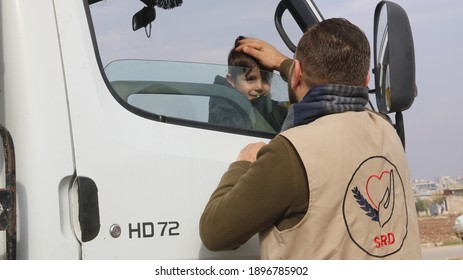 A Humanitarian Aid Worker Plays With A Syrian Refugee Child. Providing Humanitarian Aid.
Aleppo, Syria 17 April 2018