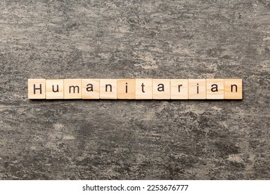 humanitarian word written on wood block. humanitarian text on table, concept.