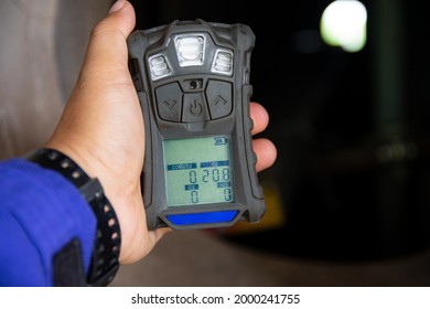 Human's hand holding the Portable Gas Detector for detect combustible gas , flammable gas , toxic gas and oxygen depletion in a confined spaces before starting work. - Shutterstock ID 2000241755