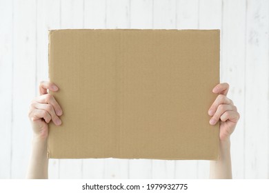 Human's Hands Holding Up Cardboard With Copy Space