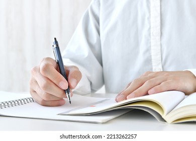 Human's hands studying hard with textbook - Shutterstock ID 2213262257