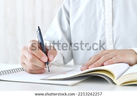 Human's hands studying hard with textbook